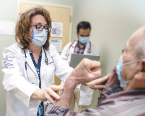 Doctora examinando a un paciente anciano