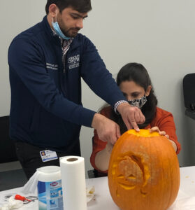 Group of medical residents carving a pumpkin