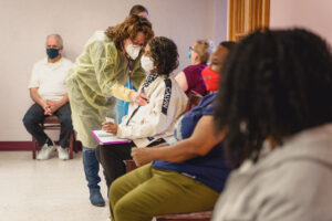 Dr. Thomas examine patient at Washington-West-COVID-Vaccine event