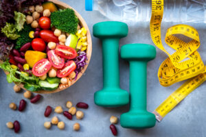 Ensalada de verduras frescas y alimentos saludables para el equipo de deporte para las mujeres de la dieta de adelgazamiento con el grifo de medida para la pérdida de peso en el fondo de madera. Concepto de deporte saludable