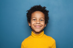 Retrato de niño feliz. Pequeño niño afroamericano sobre fondo azul