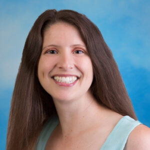 Tiffany's smiling headshot with long brown hair and blue top