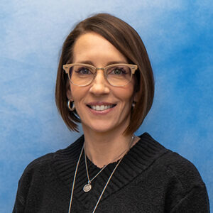 certified registered nurse practitioner Stephanie Tanona's headshot smiling in glasses with black sweater