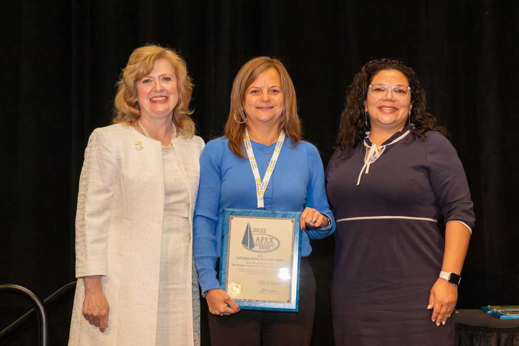 Kari Machelli, a registered nurse and associate vice president of Integrated Primary Health Services at The Wright Center, center, accepts the 2022 APEX at the Pennsylvania Association of Community Health Centers Annual Conference and Clinical Summit.