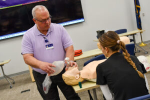 Mark Powell in purple golf shirt teaching American Heart Association class