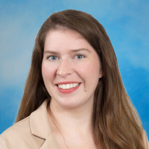 Sara's smiling headshot with tan top and long brown hair
