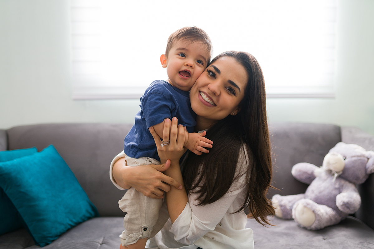 Mother and baby boy looking happy at home