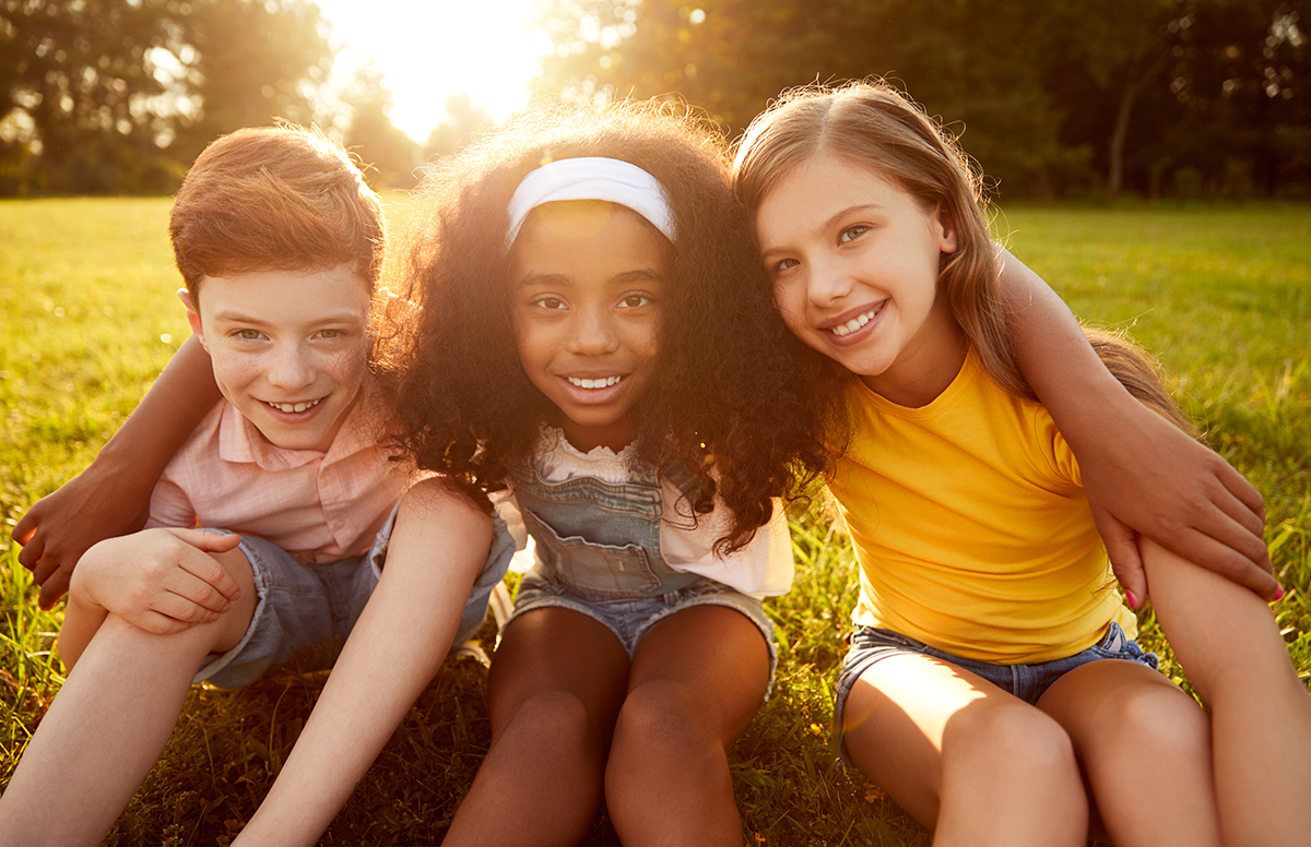 Cheerful friends hugging in park