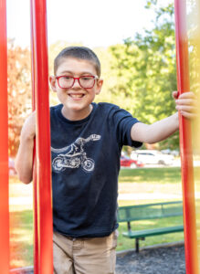twelve year old boy smiling at a park