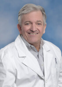 Dr. Dempsey's smiling portrait with white coat and blue background