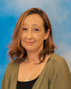 Nicole's portrait with blue background and green top