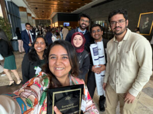 residents' selfie in a group at a prestation day holding their posters and plaque