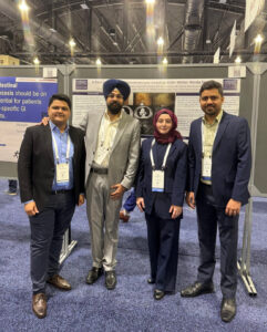 Internal medicine resident physicians who presented their poster at The American College of Gastroenterology Annual Scientific Meeting in Philadelphia, Pennsylvania, in October 2024 are standing in front of their poster