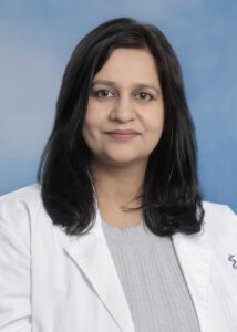Dr Sharma's headshot with white jacket and dark hair