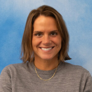 Andi Orpin's headshot smiling in grey top