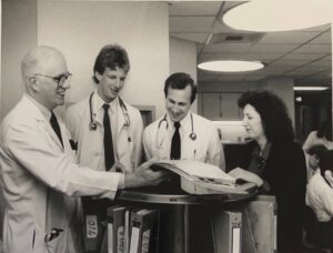 Internal Medicine residents and Dr. Robert Wright (far left) look over a patient's chart in the hospital
