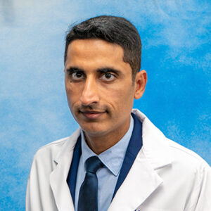 Geriatrics fellow Muhammad Siddiq Asghar headshot in white coat and on blue background