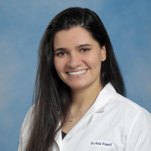 IM resident Avia Yossefi headshot in white coat on blue background
