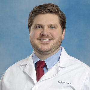 pmr resident brian smith headshot in white coat and on blue background