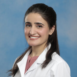 IM resident Ghazala Munawar headshot in white coat and on blue background