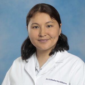 IM resident Gulzhauhar Nurdildayeva headshot in white coat on blue background