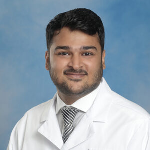 IM resident Muhammad Bilal Javaid headshot in white coat and on blue background