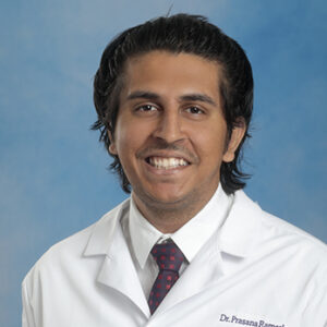 Cardio fellow Prasana Ramesh headshot in white coat and on blue background