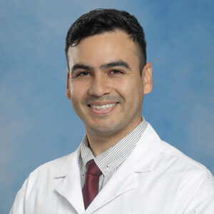IM resident Raul Rodriguez-Nunez headshot in white coat on blue background