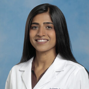 IM resident Sumiya Jatoi headshot in white coat and on blue background