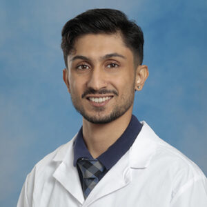 IM resident Haider Abidi headshot in white coat and on blue background