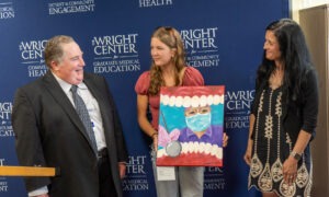 Madelyn Graves, 16, center, presents a painting to Dr. Frank Pagano, the dentist at The Wright Center for Community Health Tunkhannock, left, and Lindsay Shalata, executive director of the Wyoming County Healthcare Center. Graves said she wants to pursue a career as a dentist or orthodontist.