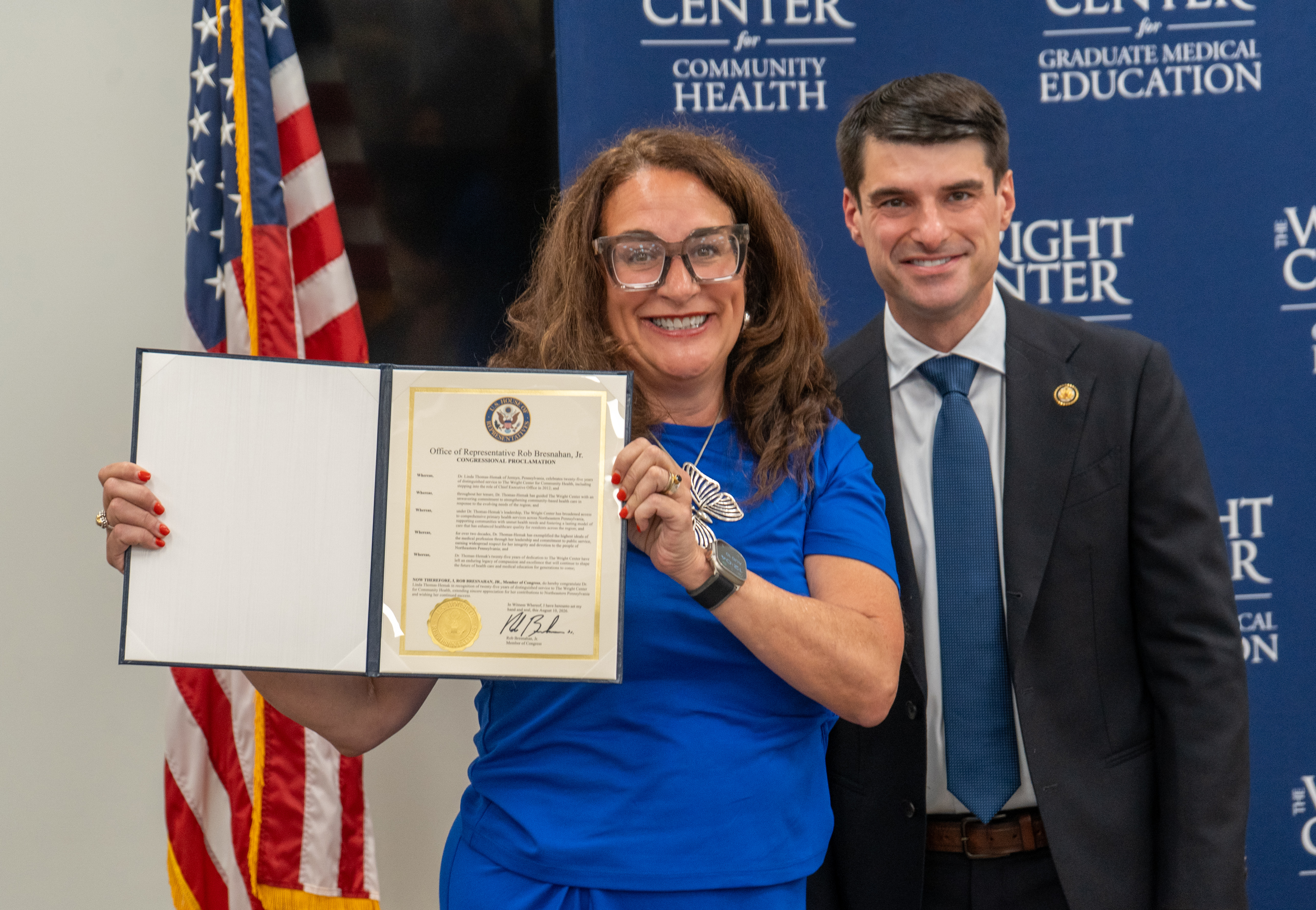 Dr. Linda Thomas-Hemak, left, holds a congressional proclamation from U.S. Representative Rob Bresnahan Jr. for her 25 years of service to The Wright Center.